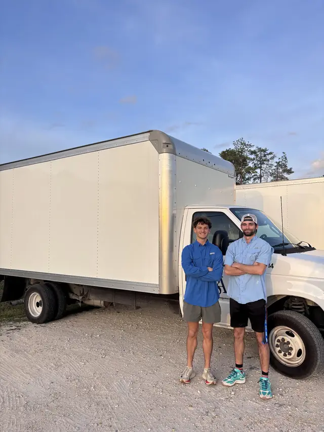 Southern Shores Moving crew standing beside their box truck at sunset
