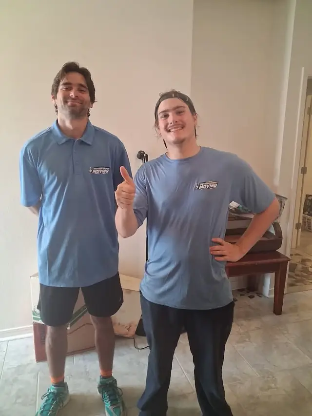 Two Southern Shores movers smiling inside a customer home after finishing a move