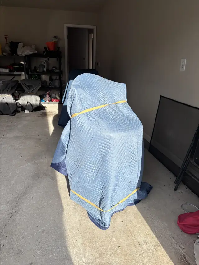Furniture padded with a blue moving blanket