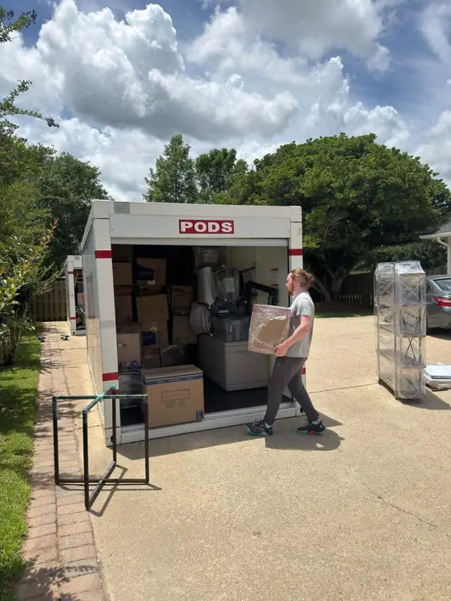 Mover carrying a box into a PODS container