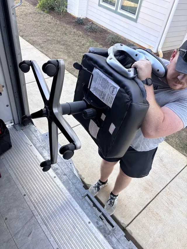 Mover unloading an office chair from the truck