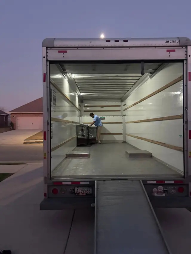 Moving truck open with ramp down at dusk