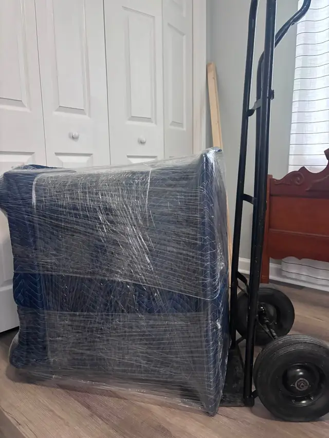 Wrapped furniture strapped to a hand truck